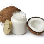 Coconut oil and fresh coconut on white background